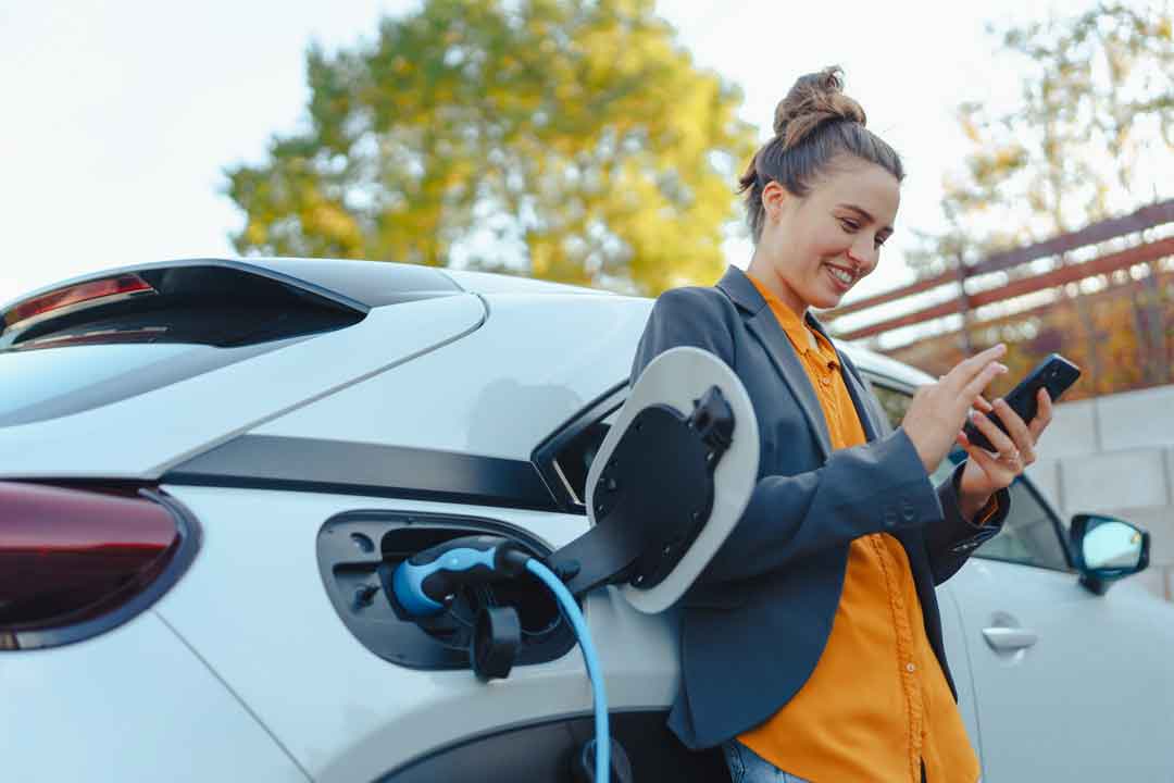 Woman on phone while car is charging